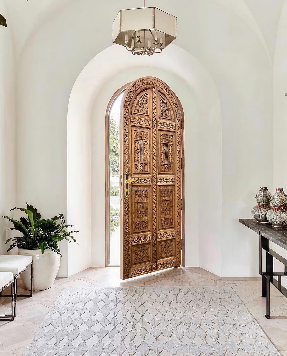 Colonial arched entry door with hand-forged iron scrollwork transom